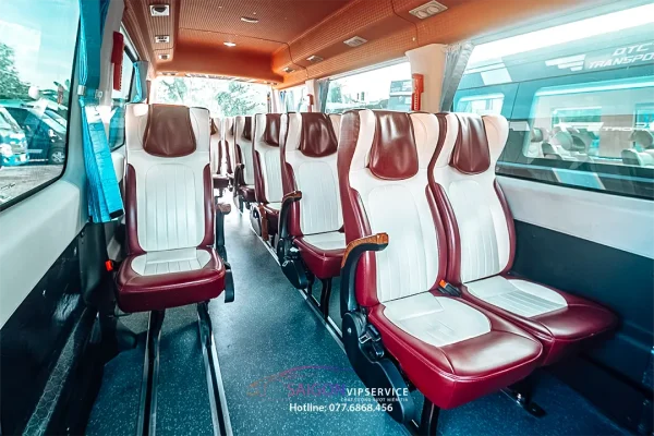 Khoang hành khách xe 19 chỗ Iveco với ghế đỏ trắng và trần cam.
