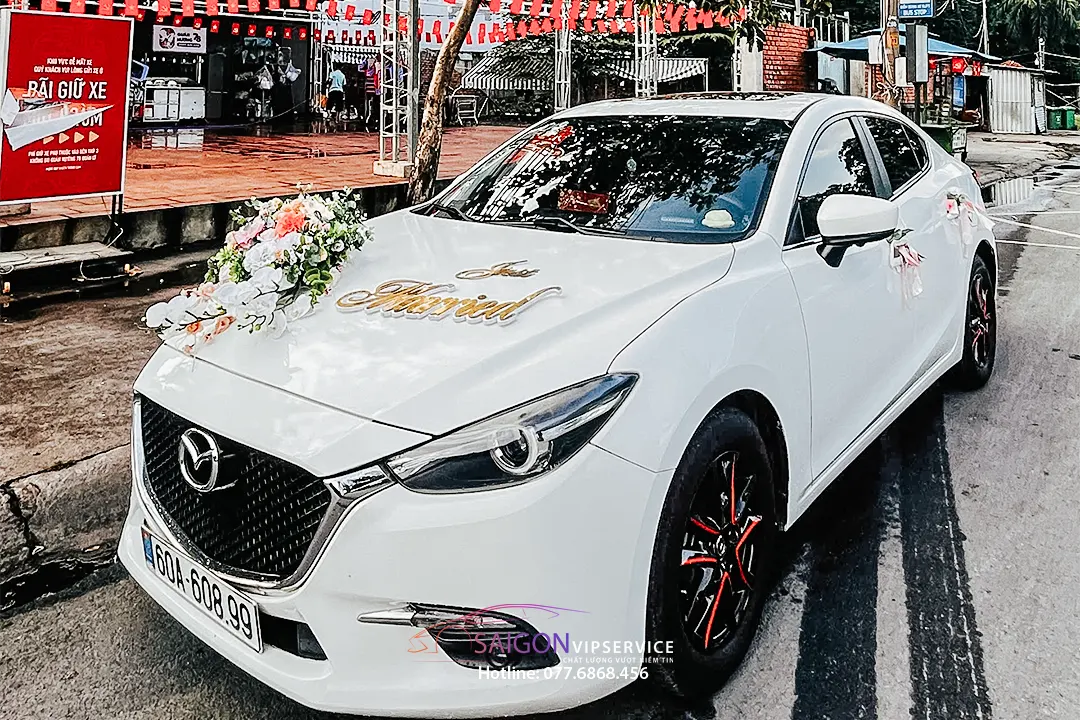 Xe hoa cưới Mazda màu trắng trang trí hoa tươi và chữ hỷ sang trọng