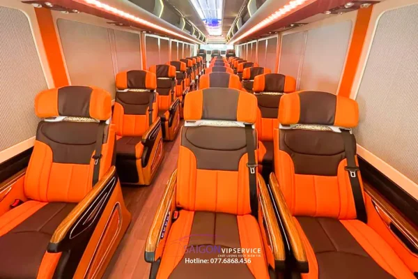 Nội thất xe limousine 27 chỗ Limited với ghế da cam và ánh sáng trần hiện đại.