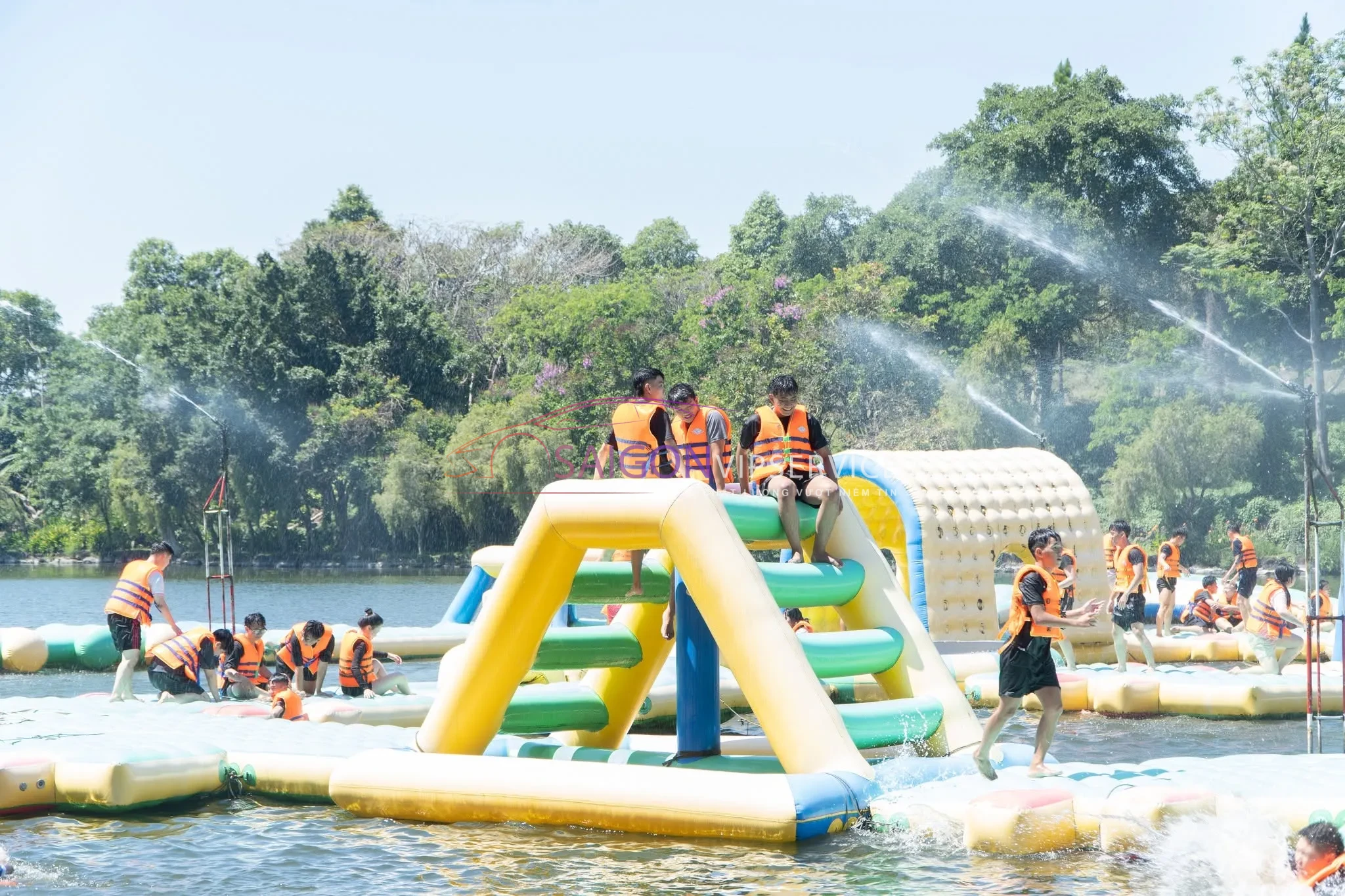 Nhóm bạn trẻ đang hào hứng tham gia các trò chơi vận động dưới nước tại khu vực Nhà phao liên hoàn của KDL Suối Mơ