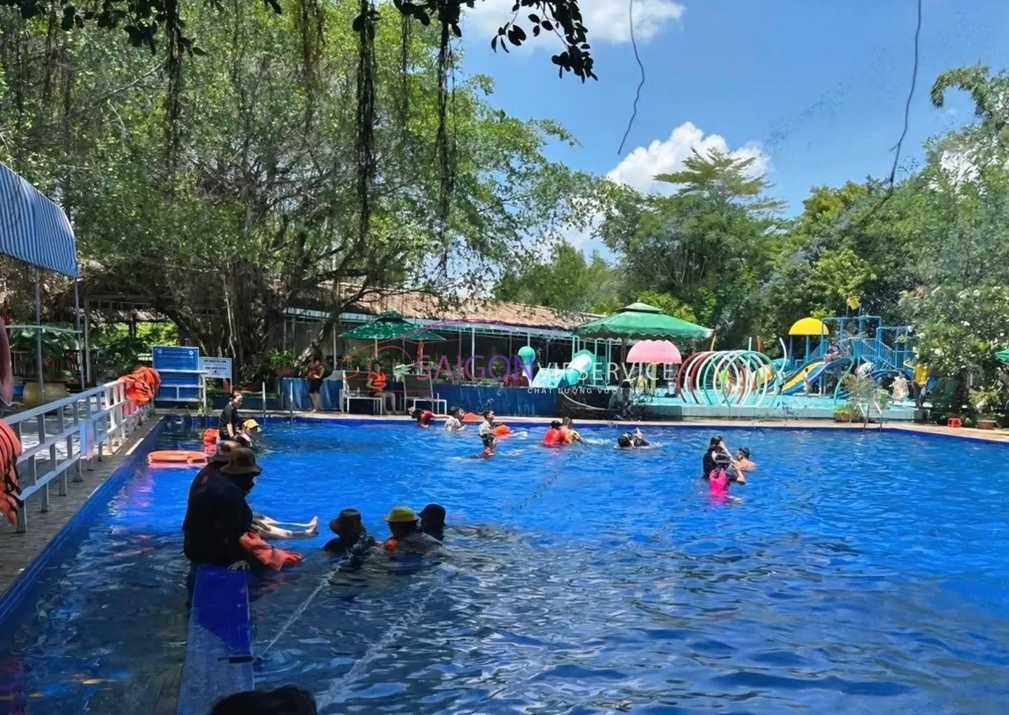 Du khách bơi lội và thư giãn tại khu vực hồ bơi ngoài trời hiện đại của Làng Du lịch sinh thái Tre Việt