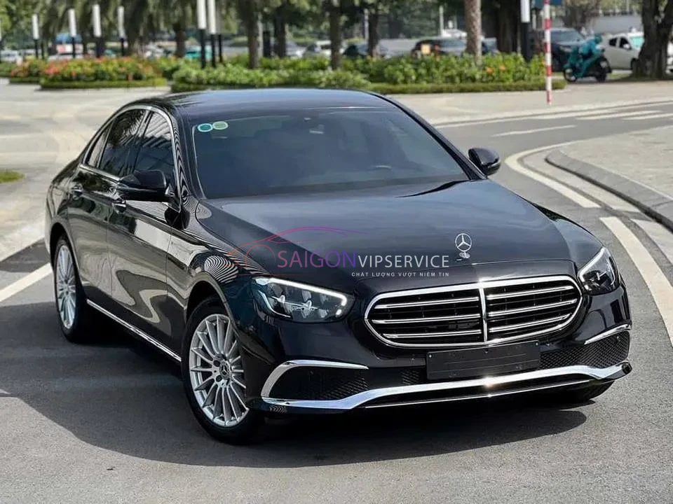 Ngoại thất đầu xe sang Mercedes E200 màu đen lịch lãm lăn bánh trên đường phố.