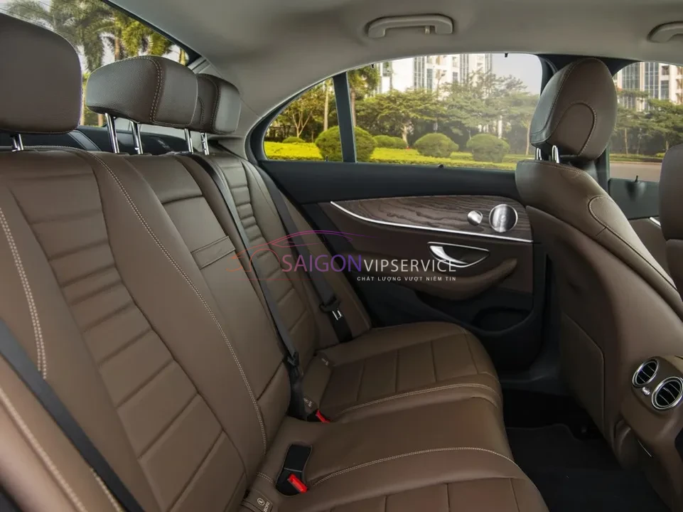Tận hưởng sự êm ái tuyệt đối tại hàng ghế sau xe Mercedes E200. Nội thất bọc da màu nâu cao cấp, không gian để chân rộng rãi, mang lại sự thư giãn trọn vẹn cho khách VIP.